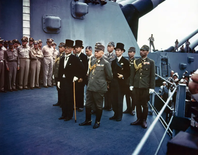 The Japanese delegation, led by Foreign Minister Mamoru Shigemitsu in a top hat and General Yoshijiro Umezu, standing in formation on the deck of USS Missouri before the surrender ceremony, 2 September 1945