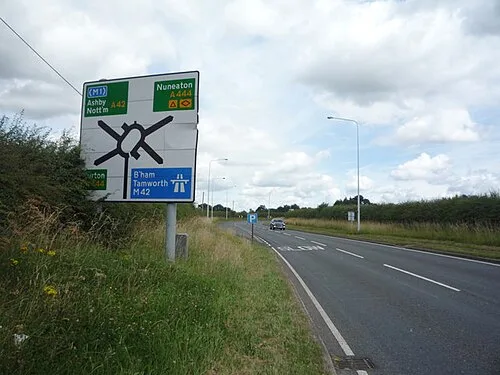 A roadside direction sign near M42 Junction 11 stacking a roundabout diagram above routes to Nuneaton, Ashby, Nottingham, Birmingham, Tamworth and the M42.