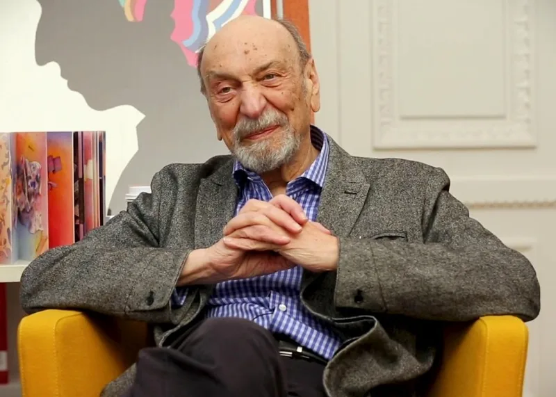 Milton Glaser, seated in a grey blazer, being interviewed at the Cooper Hewitt, Smithsonian Design Museum in 2016